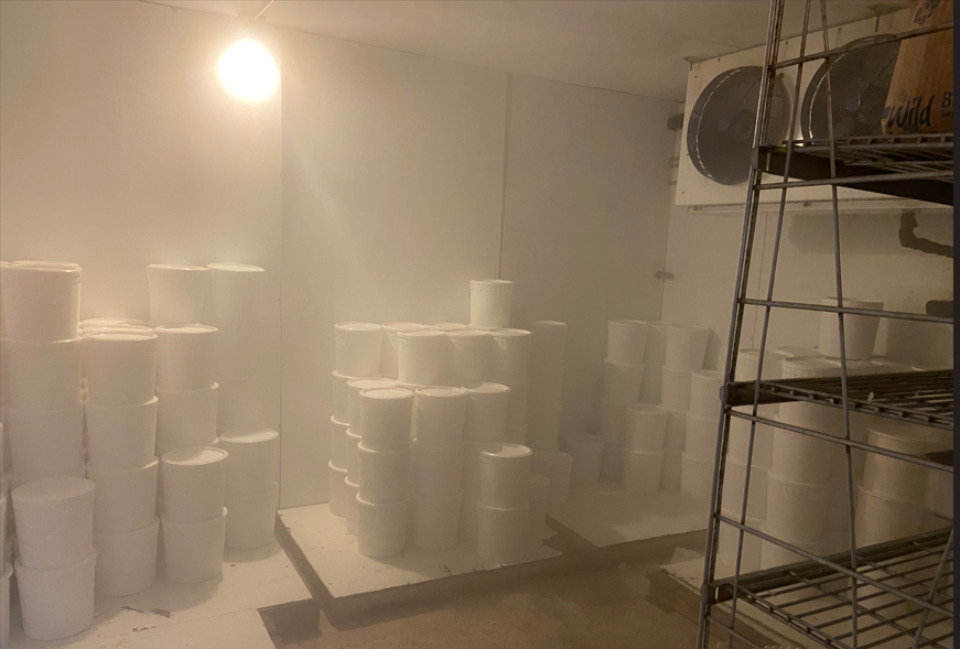 Cold storage room with stacked ice cream buckets